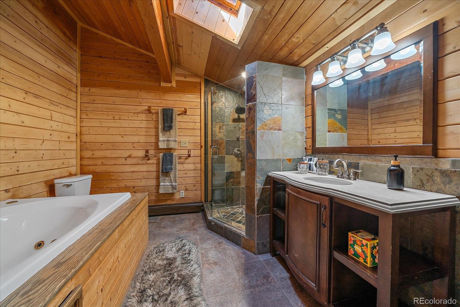 1385 Beaver Brook Canyon Road Evergreen, CO 80439 - Photo 27 of 49 a bathroom with a double vanity sink a toilet and shower