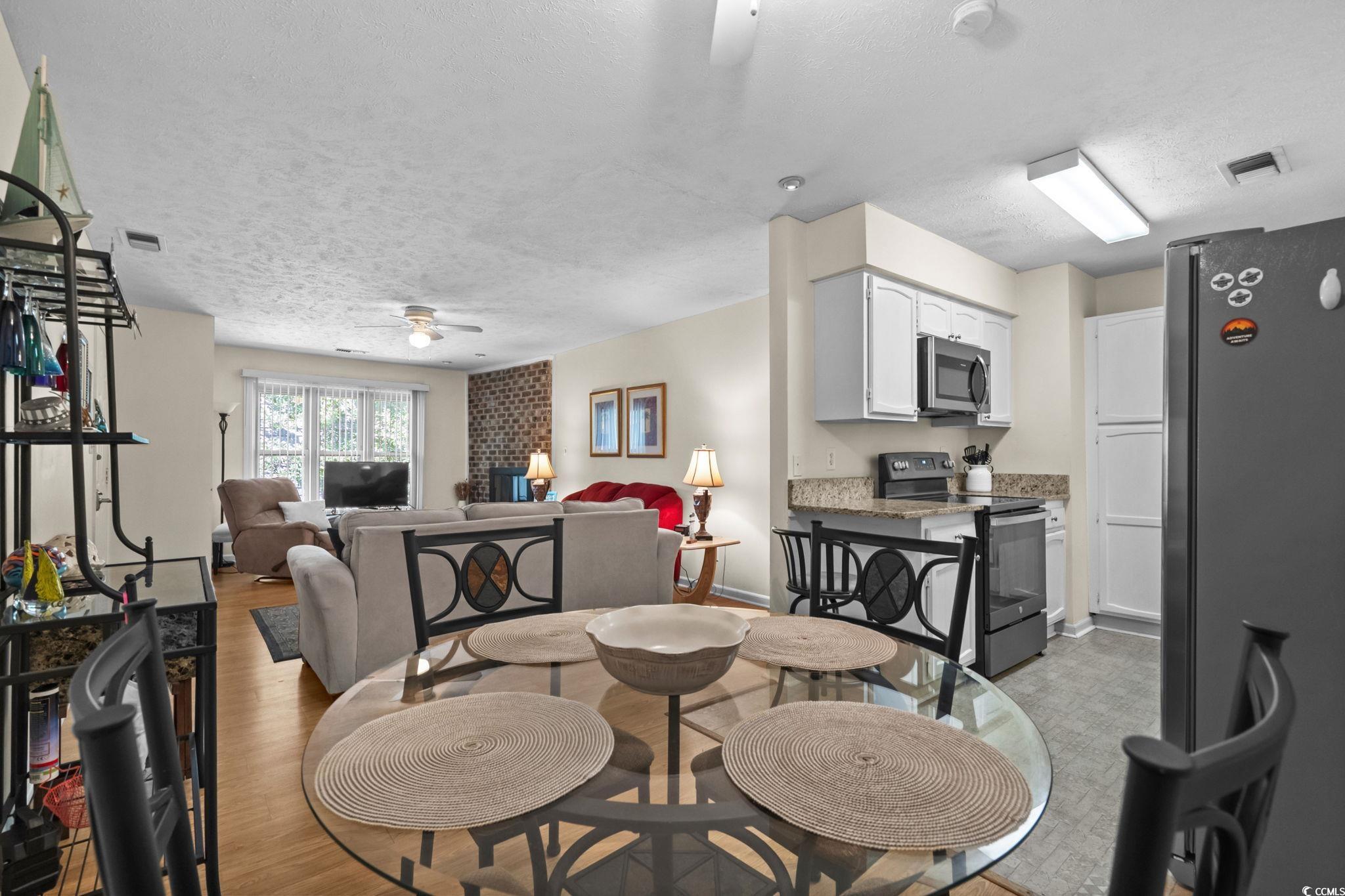 406 75th Avenue North, Unit Q Myrtle Beach, SC 29572 - Photo 11 of 23 Dining area featuring a ceiling fan, a textured ceiling, and light wood-type flooring