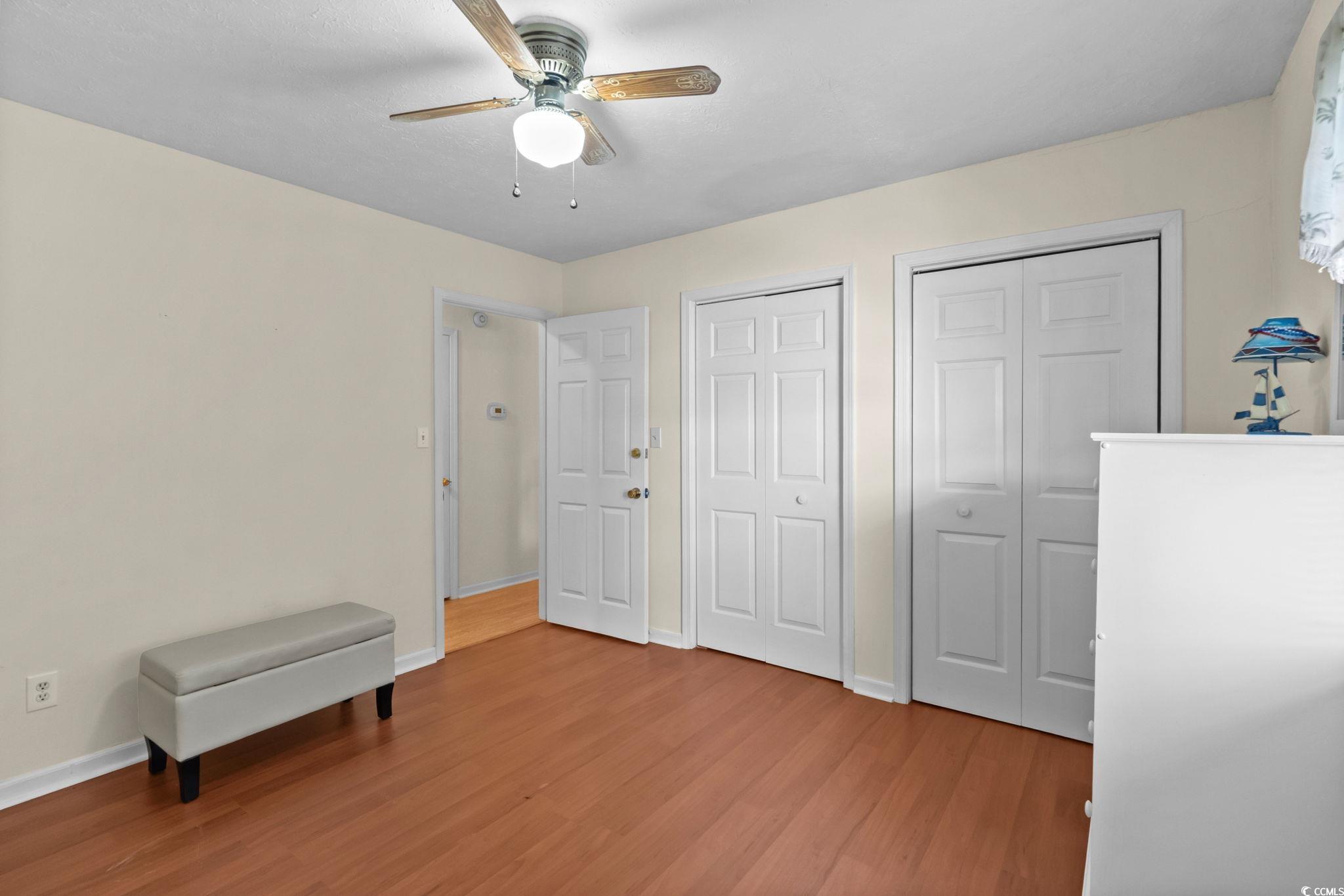 406 75th Avenue North, Unit Q Myrtle Beach, SC 29572 - Photo 18 of 23 Bedroom with multiple closets, light wood finished floors, and ceiling fan