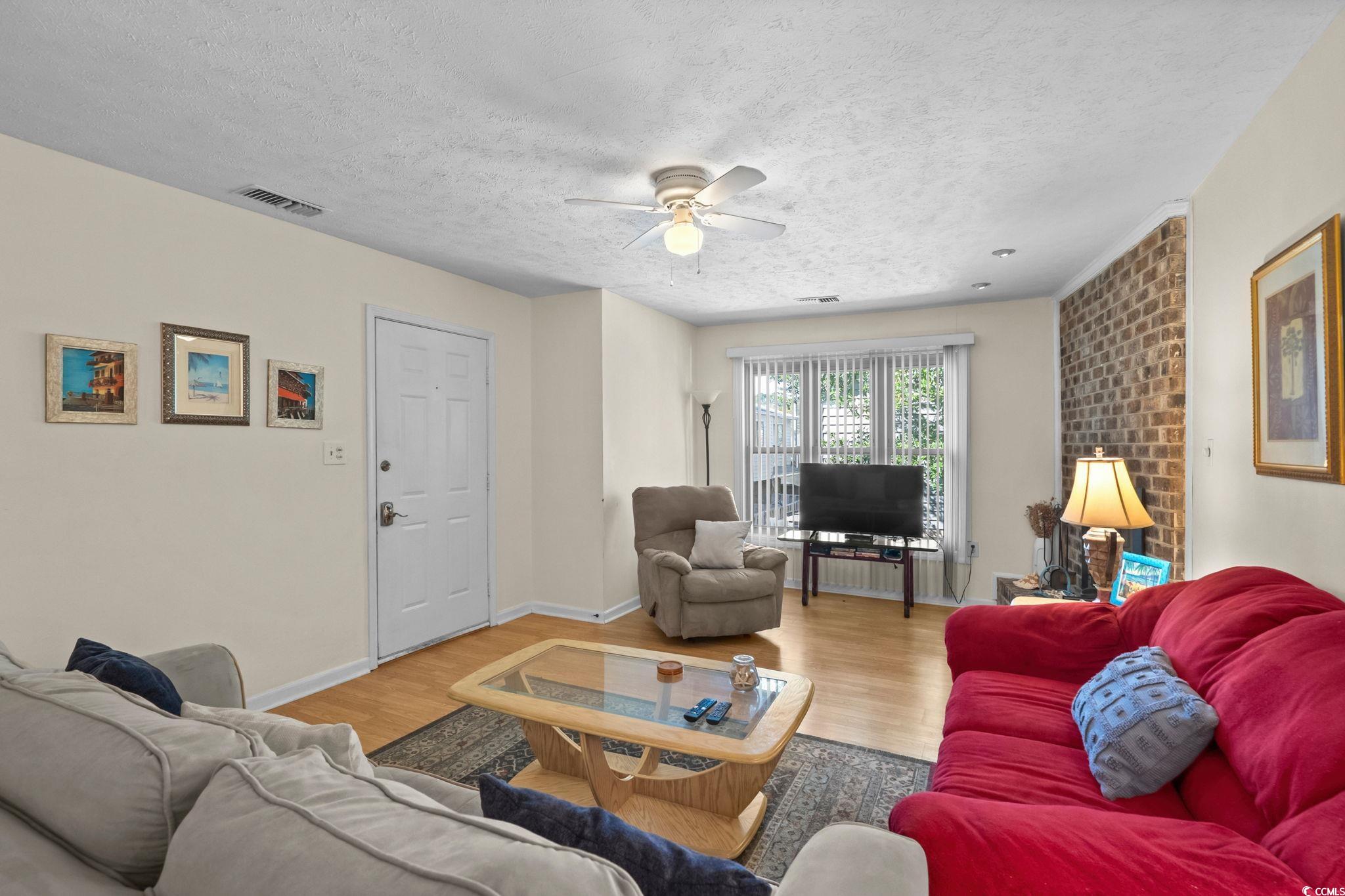 406 75th Avenue North, Unit Q Myrtle Beach, SC 29572 - Photo 4 of 23 Living room featuring wood finished floors, ceiling fan, and a textured ceiling