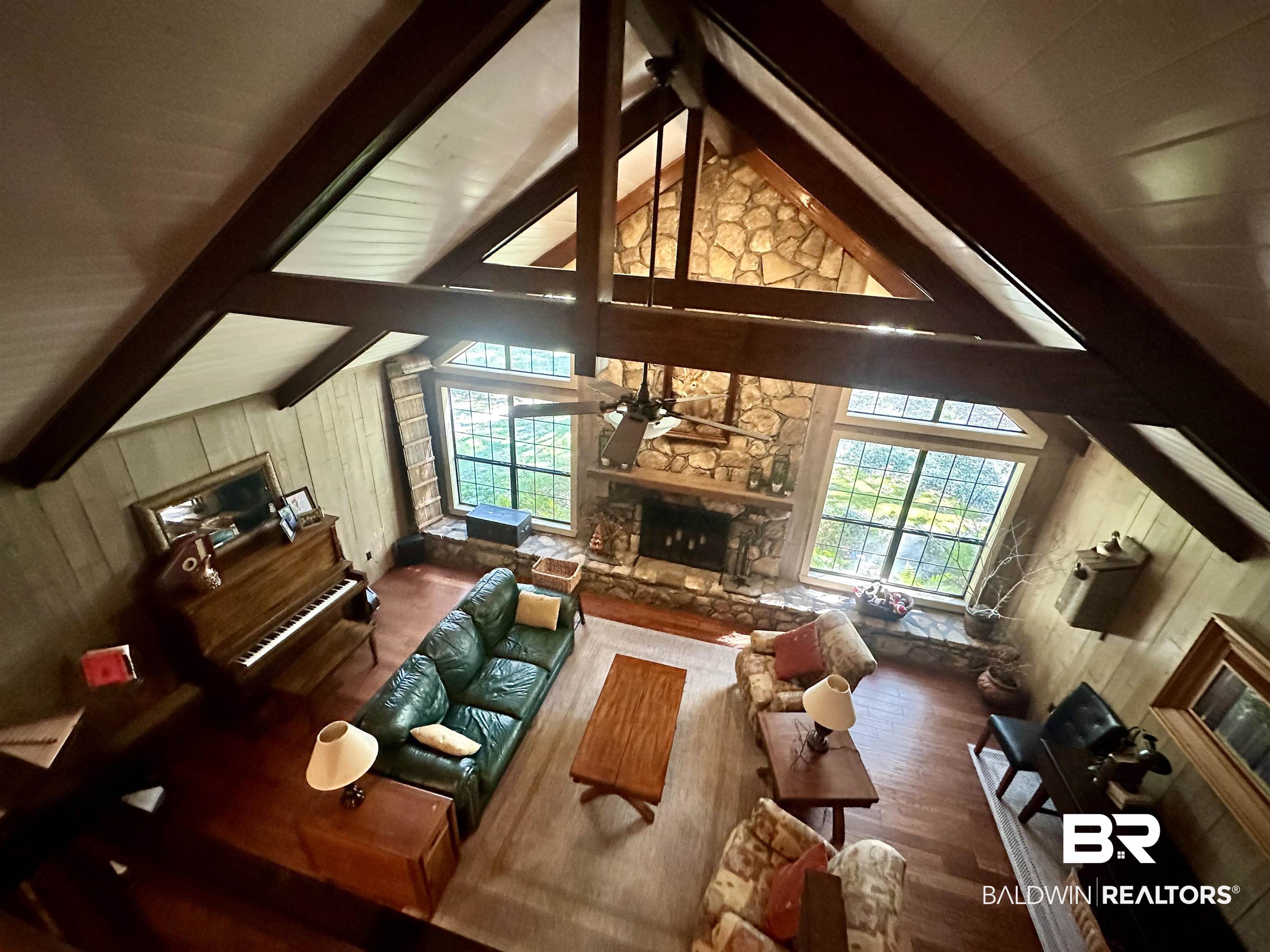 117 Belle Meade Brewton, AL 36426 - Photo 2 of 62 Living room featuring wood walls, hardwood / wood-style flooring, a wealth of natural light, and a stone fireplace