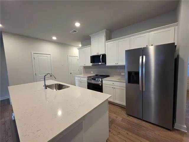a kitchen with a refrigerator and a stove top oven