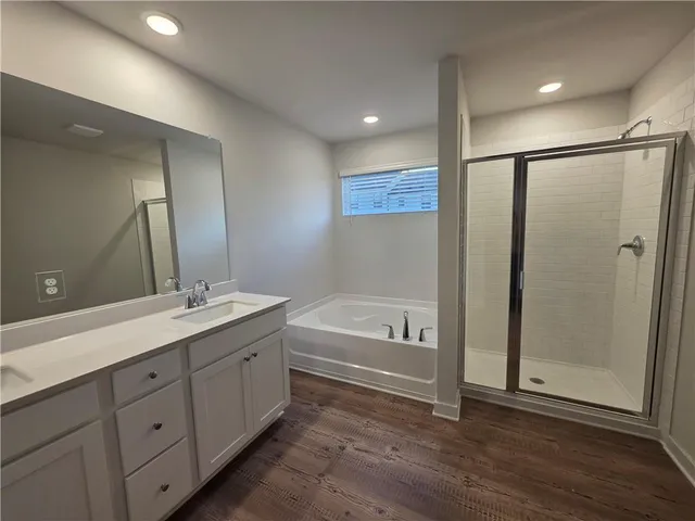 a bathroom with a tub a sink and mirror