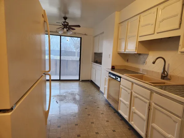 a kitchen with a refrigerator sink and cabinets