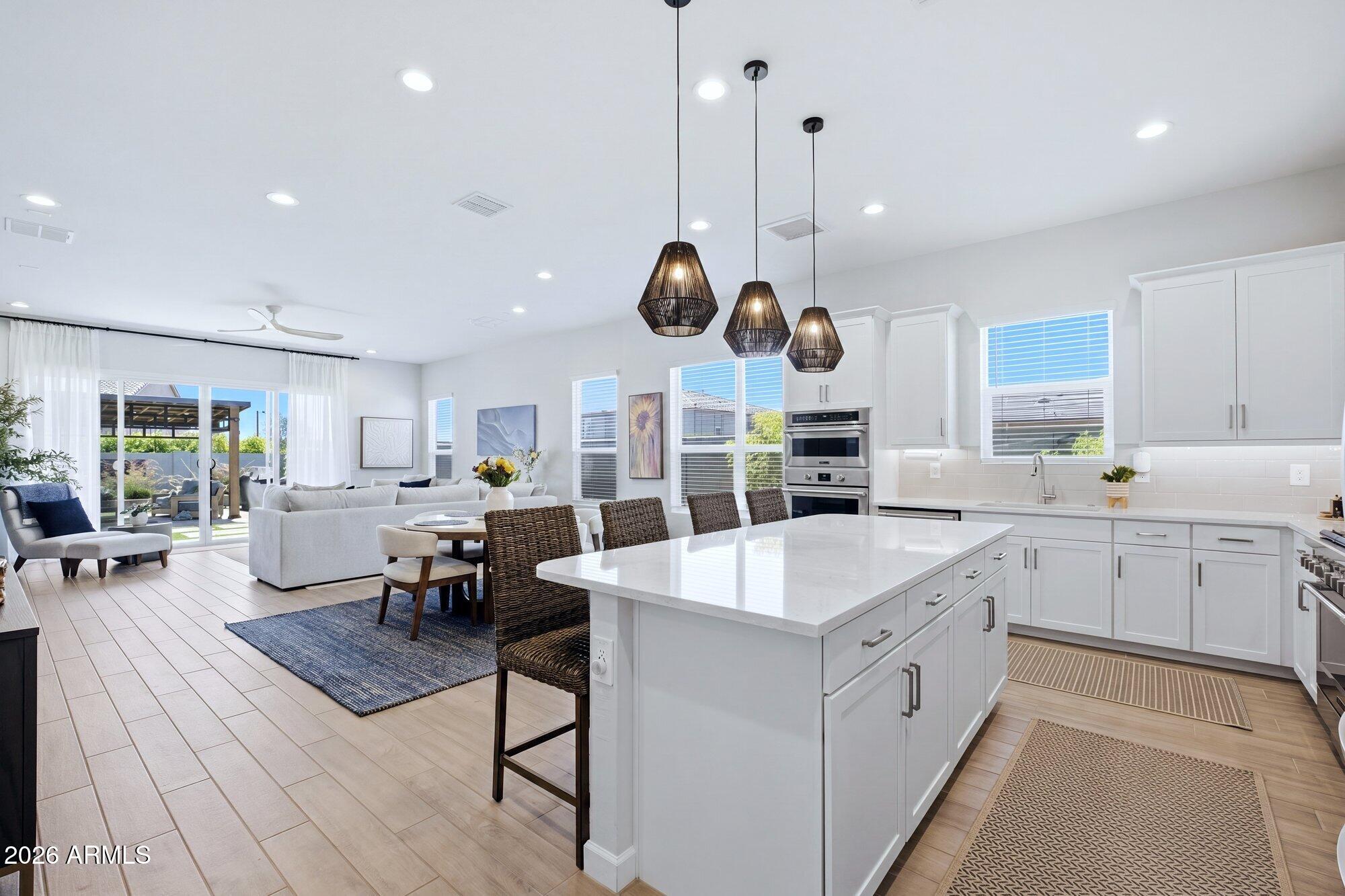 5963 East Lone Cactus Road Phoenix, AZ 85054 - Photo 5 of 22 a large kitchen with stainless steel appliances lots of counter space and wooden floor
