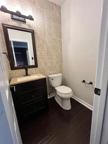 a bathroom with a toilet sink and mirror