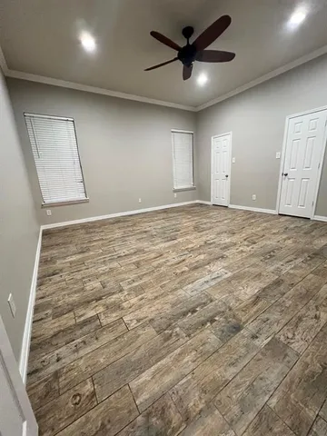 an empty room with wooden floor and windows