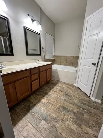 a bathroom with a tub sink and mirror