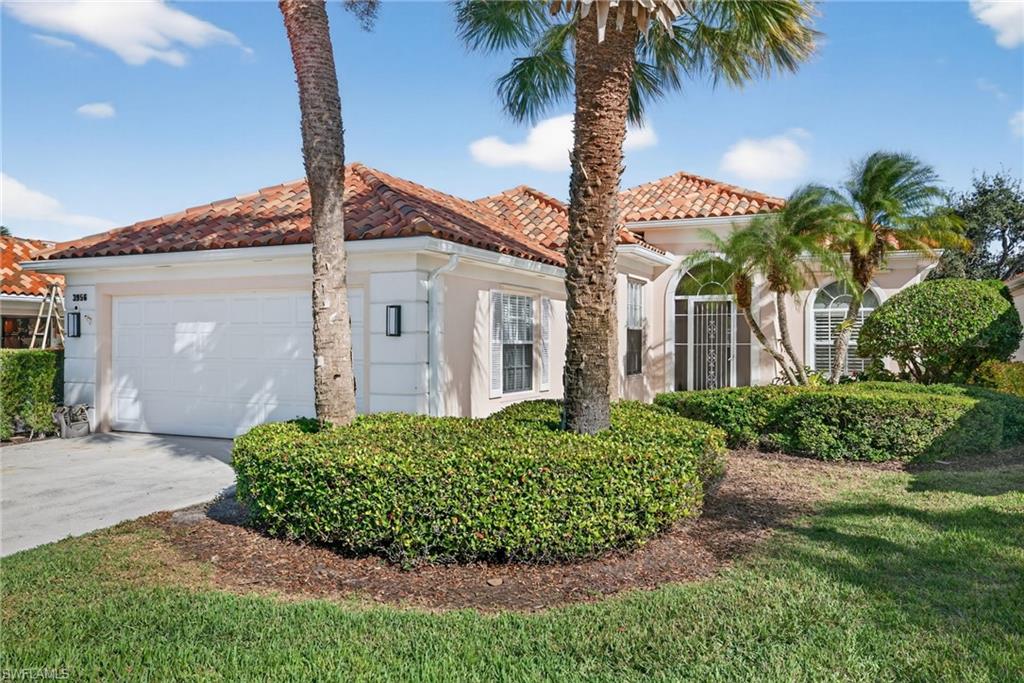 Mediterranean / spanish-style house featuring stucco siding, driveway, a garage, a tiled roof, and a front yard