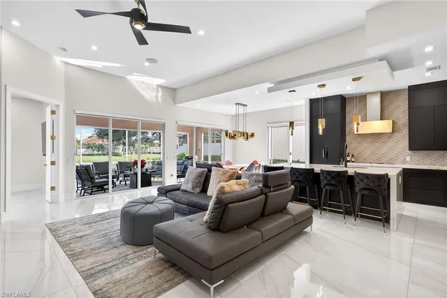 a living room with furniture kitchen view and a large window
