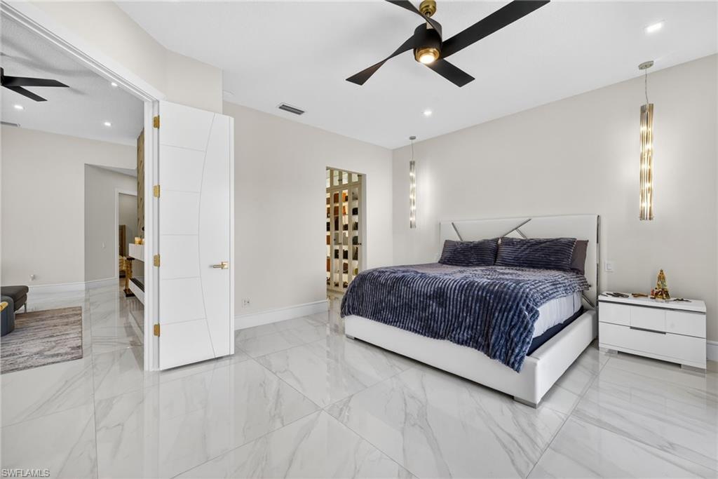 3956 Isla Ciudad Court Naples, FL 34109 - Photo 15 of 39 Bedroom featuring light marble finish flooring and a ceiling fan