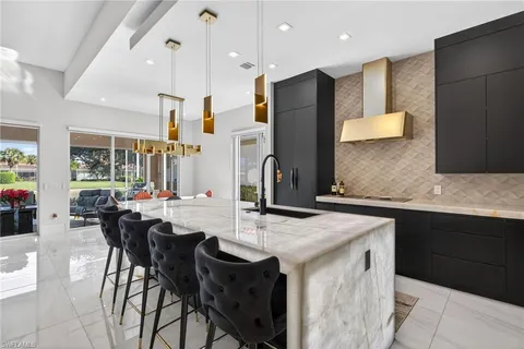 a kitchen with stainless steel appliances granite countertop table chairs sink and cabinets