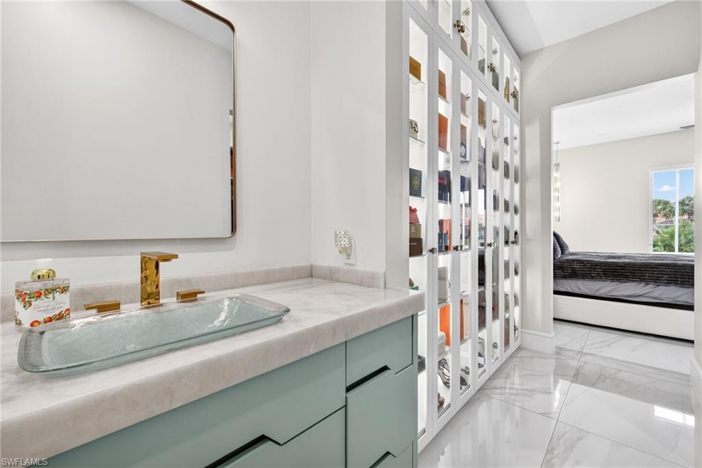 3956 Isla Ciudad Court Naples, FL 34109 - Photo 21 of 39 Bathroom with light marble finish floors, connected bathroom, vanity, and french doors