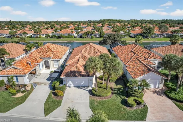 an aerial view of residential houses with outdoor space and lake view