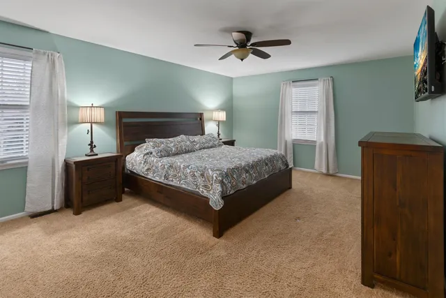 a large bedroom with a bed and a flat screen tv