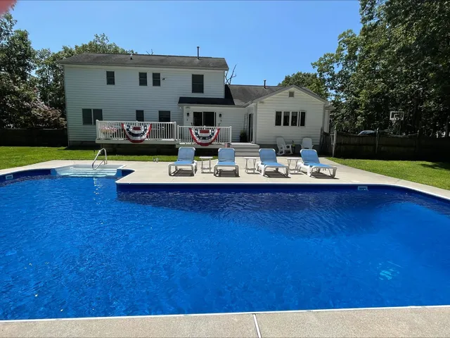 a view of a house with swimming pool and a yard