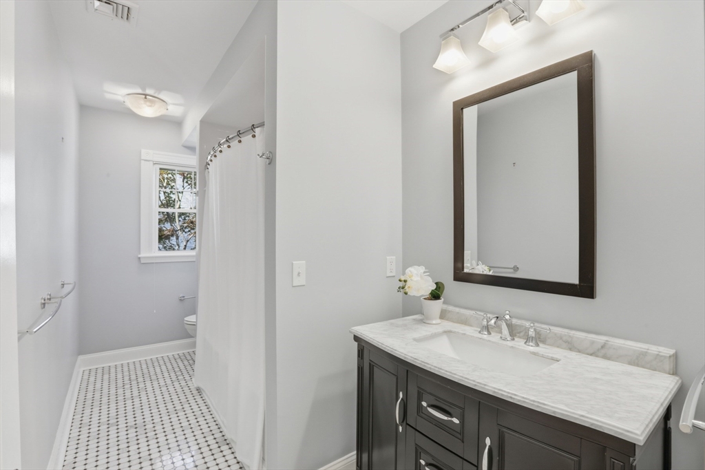 16 Park Avenue, Unit 2 Winchester, MA 01890 - Photo 26 of 32 a bathroom with a sink a mirror and a shower