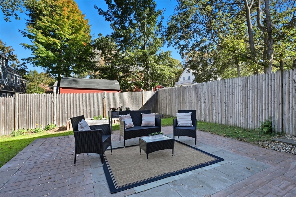 16 Park Avenue, Unit 2 Winchester, MA 01890 - Photo 29 of 32 a view of backyard with table and chairs and wooden fence