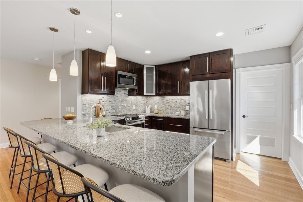16 Park Avenue, Unit 2 Winchester, MA 01890 - Photo 10 of 32 a kitchen with stainless steel appliances granite countertop a sink refrigerator and cabinets