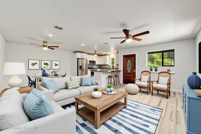 a living room with furniture kitchen view and a chandelier