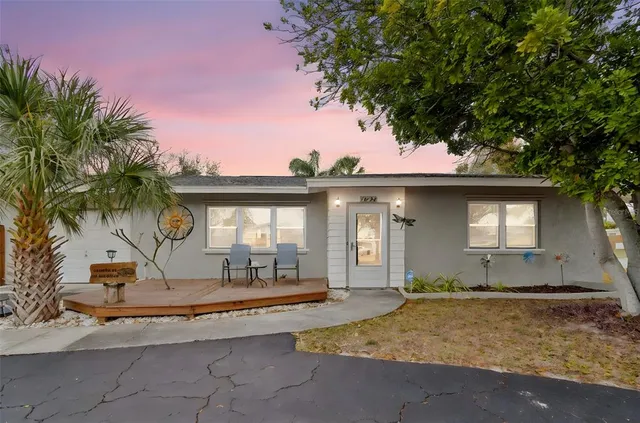 a view of a house with a swimming pool and sitting area