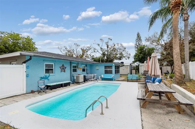 a view of a house with swimming pool and sitting area