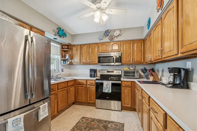 a kitchen with stainless steel appliances granite countertop a refrigerator a stove top oven a sink and dishwasher