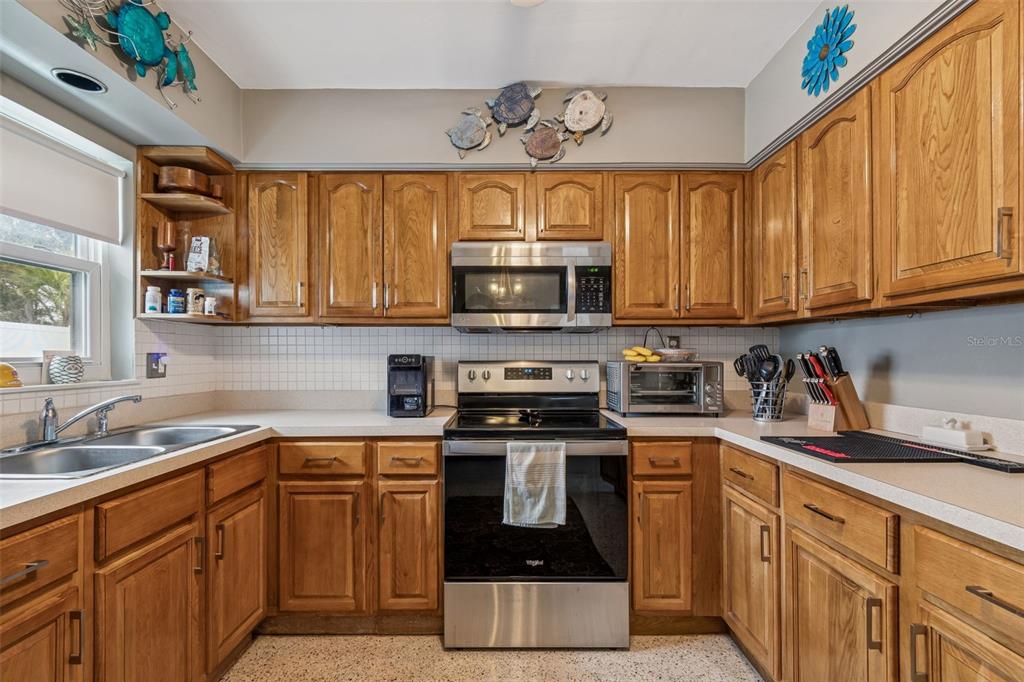 12424 105th Street Largo, FL 33773 - Photo 8 of 45 a kitchen with stainless steel appliances granite countertop a stove a sink and a microwave