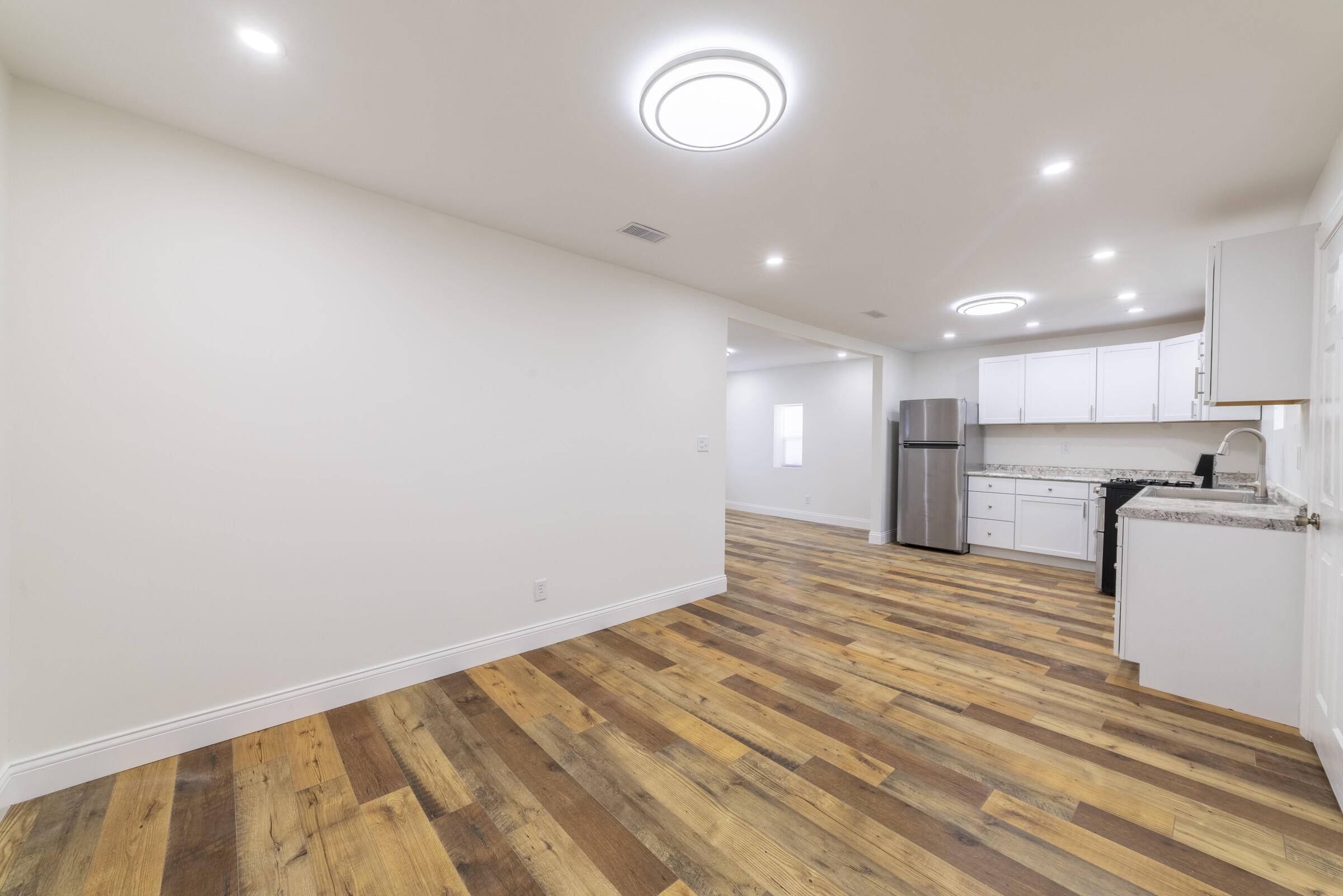 4645 Hayes Street Gary, IN 46408 - Photo 9 of 33 a view of kitchen and empty room with wooden floor