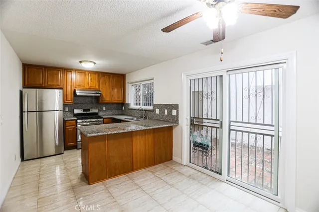 a kitchen with stainless steel appliances granite countertop a refrigerator oven a sink and dishwasher