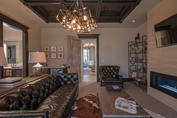 a living room with furniture a chandelier and a fireplace