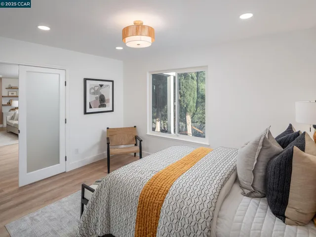 a bedroom with a large bed and a chandelier