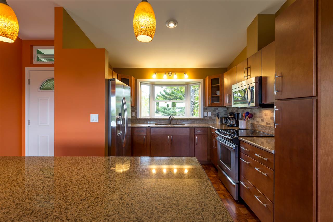 890 East Kuiaha Road Haiku, HI 96708 - Photo 21 of 30 a kitchen with stainless steel appliances granite countertop a stove and a refrigerator