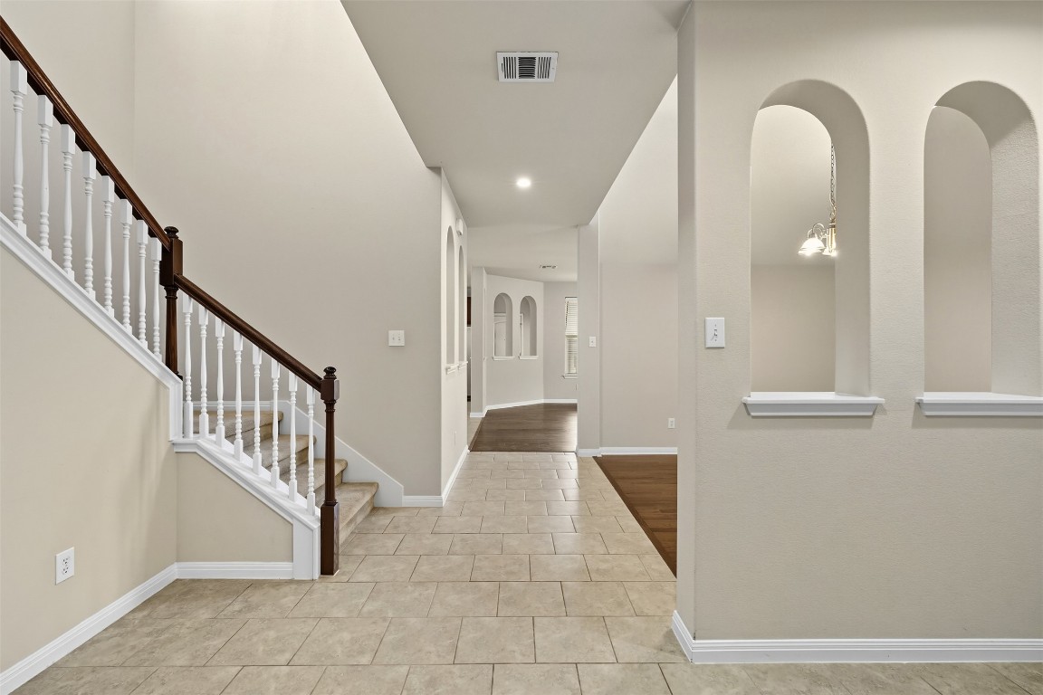 111 Sycamore Street Georgetown, TX 78633 - Photo 4 of 22 a view of staircase with lots of frames on wall and a chandelier