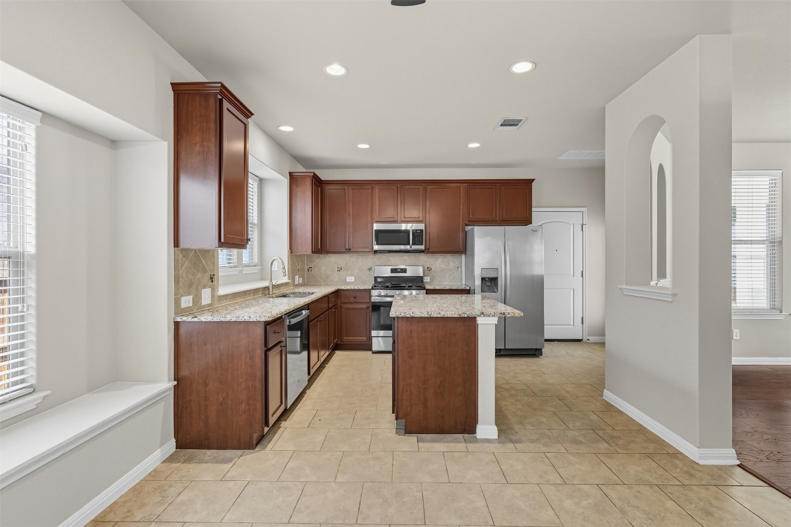 111 Sycamore Street Georgetown, TX 78633 - Photo 6 of 22 a kitchen with stainless steel appliances granite countertop a refrigerator a sink a stove a microwave and island