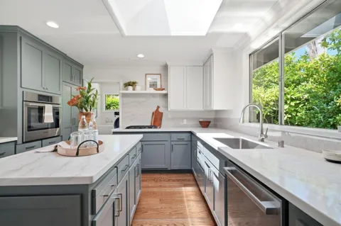 a kitchen with a sink stove top oven and refrigerator