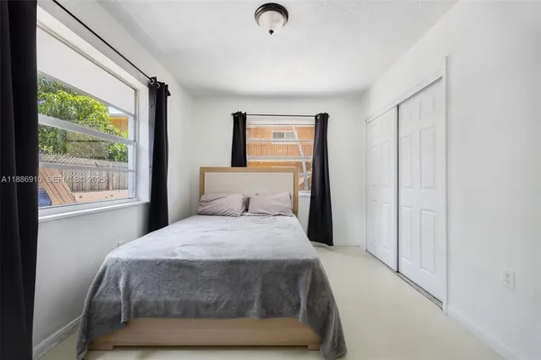 a bedroom with a bed lamp and a window