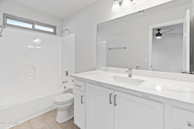 a bathroom with a sink a toilet and a large mirror