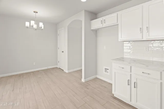 an empty room with wooden floor and cabinet