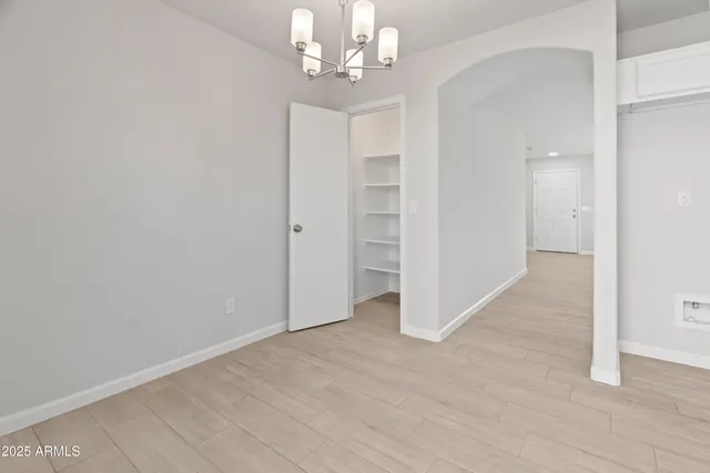 wooden floor in an empty room with a chandelier