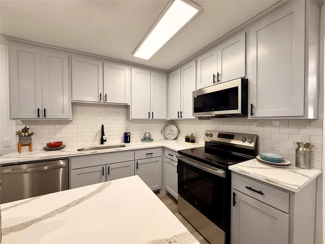 a kitchen with a sink stove and microwave