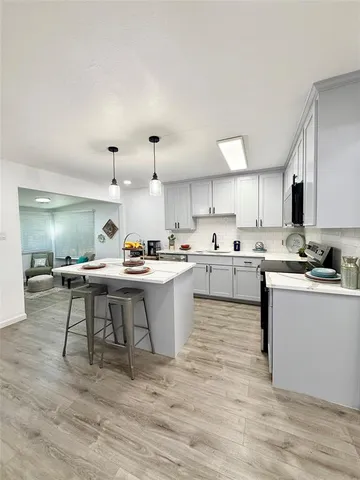 a kitchen with a sink cabinets and wooden floor