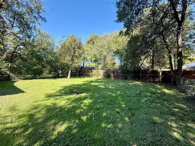 a view of green field with trees in the background