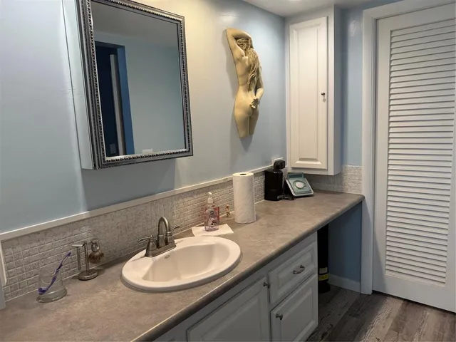 a bathroom with a granite countertop sink and a mirror