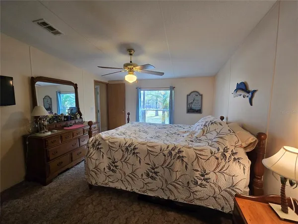 a bed sitting in a bedroom and night stand