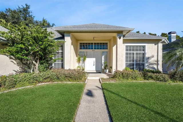 a front view of a house with a yard and potted plants