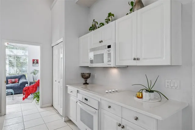 a kitchen with white cabinets and window