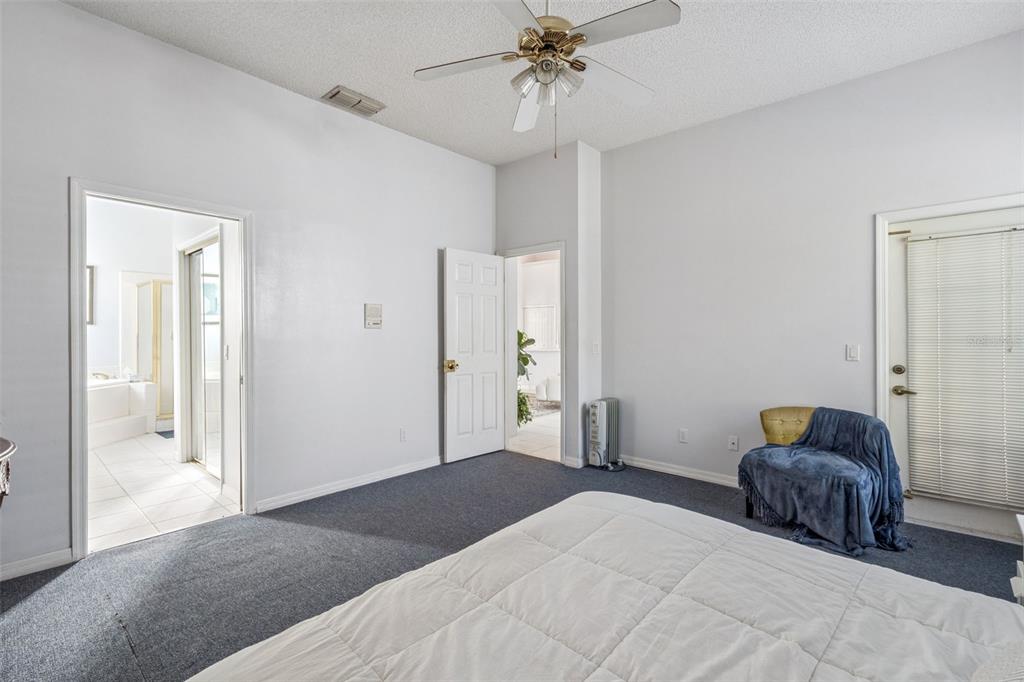 3447 Amaca Circle Orlando, FL 32837 - Photo 17 of 30 a bedroom with a bed and a chandelier