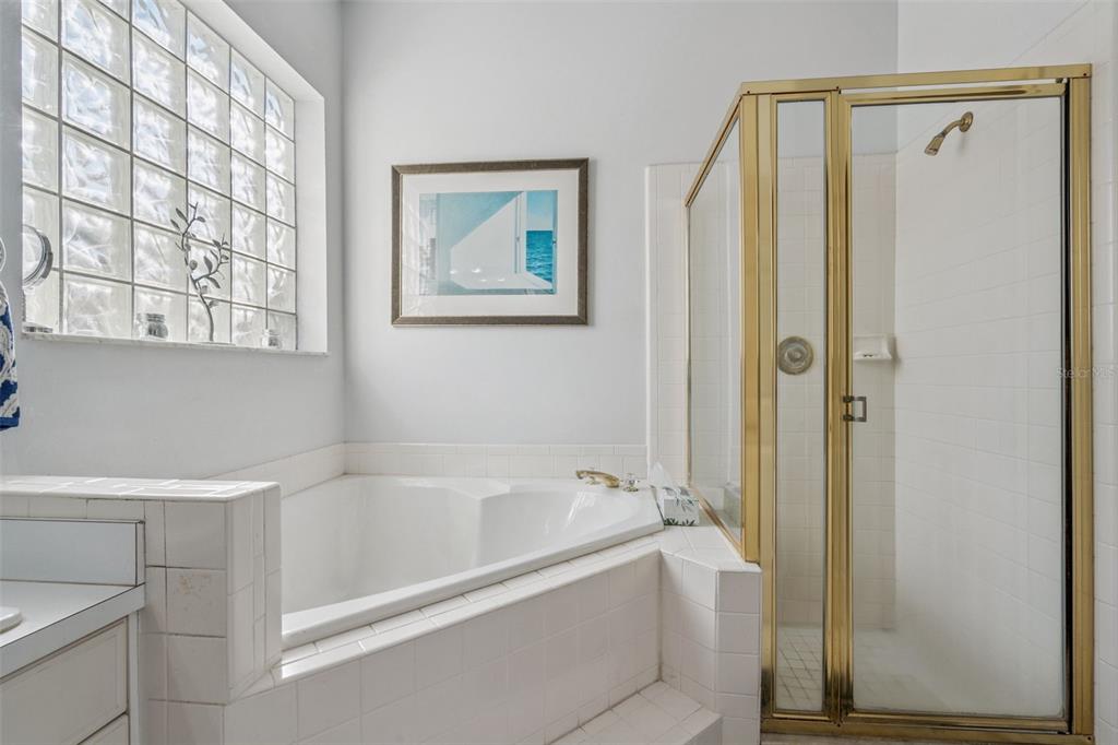 3447 Amaca Circle Orlando, FL 32837 - Photo 18 of 30 a white bath tub sitting next to a white sink and a mirror