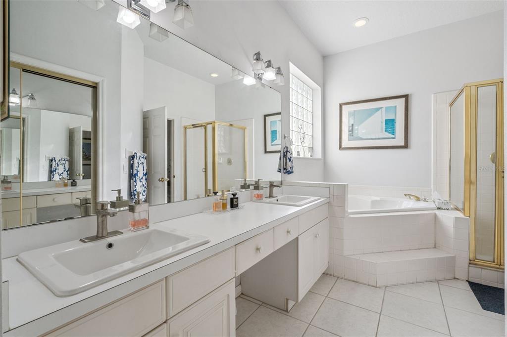 3447 Amaca Circle Orlando, FL 32837 - Photo 19 of 30 a bathroom with a sink a large mirror and a bathtub